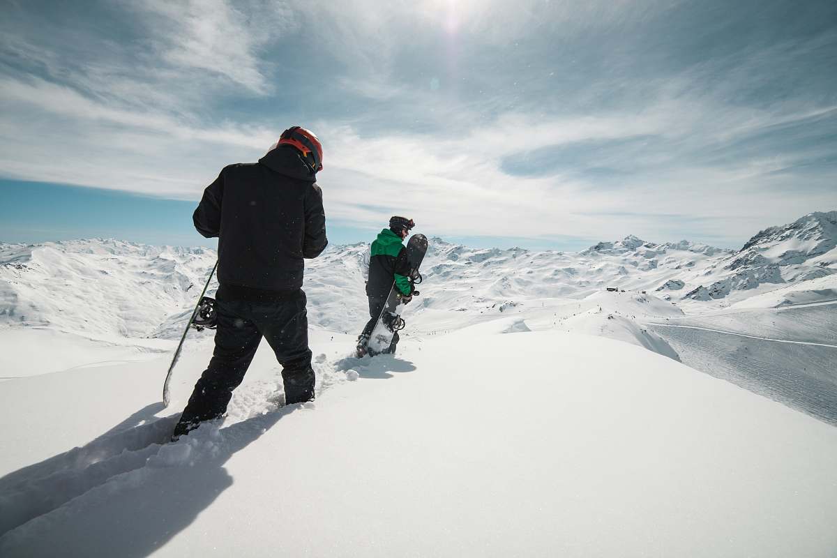 les menuires two people carrying snowboards on snow covered terrain snow